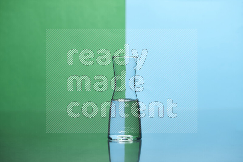 The image features a clear glassware filled with water, set against green and light blue background