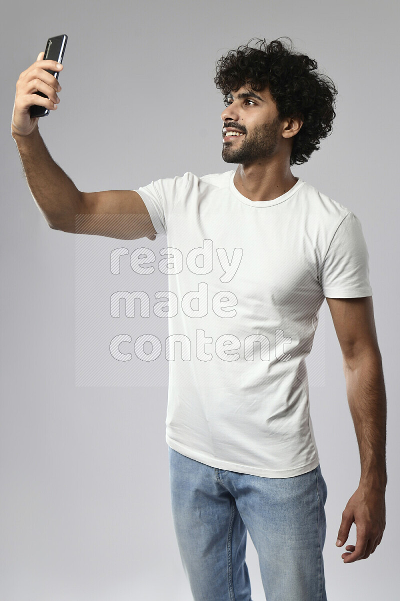 رجل يرتدي ملابس كاجوال يلتقط صورة شخصية علي خلفية بيضاء