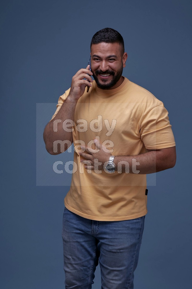 A man Calling on Blue Background wearing Orange T-shirt