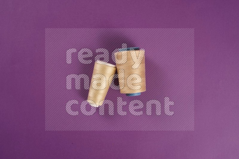 Beige sewing supplies on purple background