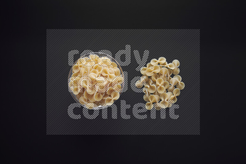 Fiocchi pasta in a glass bowl on black background