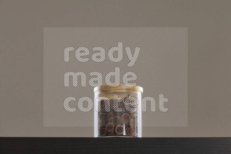 أزرار متنوعة في وعاء زجاجي علي خلفية سوداء