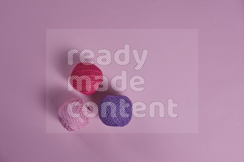 مجموعة من أدوات الخياطة والتفصيل أرجوانية وزهرية اللون على خلفية زهرية