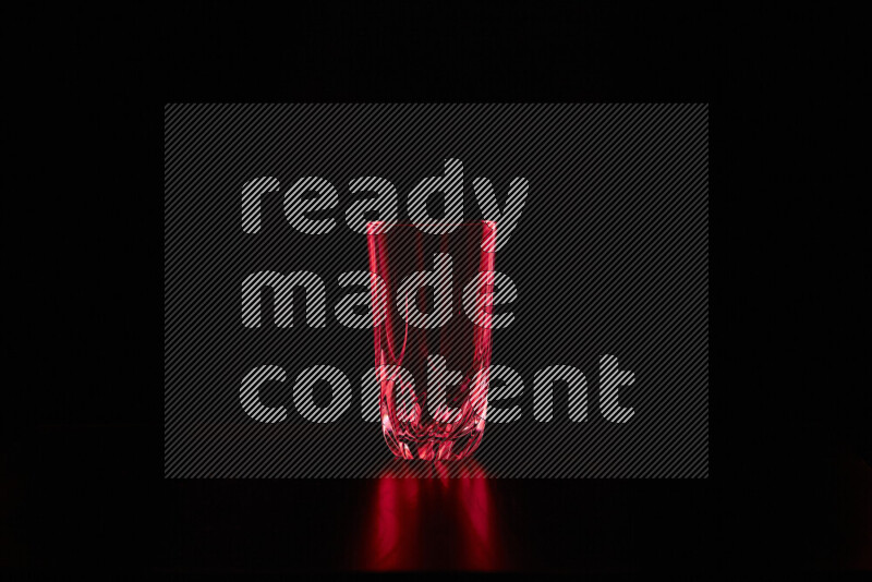 Glassware with rim light in red against black background