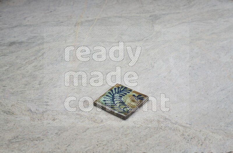 Top view shot of a pottery coaster\ tile on beige marble flooring