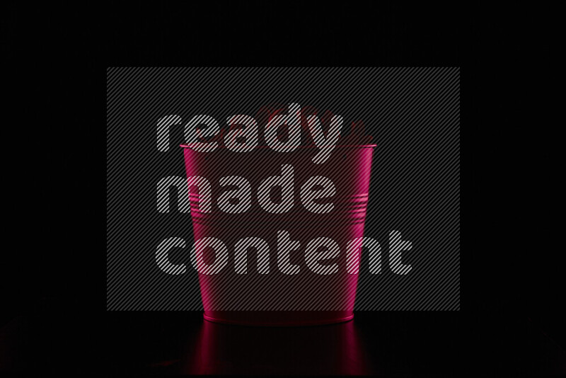 A plant pot with colored rim light against black background