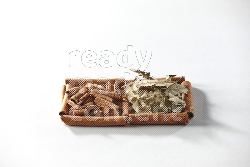 2 squares of cinnamon sticks full of cinnamon and bay laurel leaves on white flooring