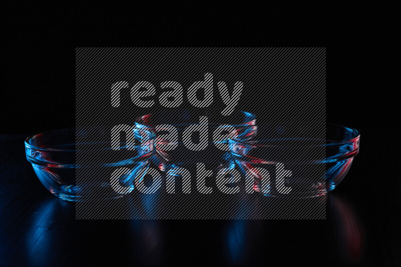 أواني زجاجية مع حواف مضيئة باللونين الأحمر والأزرق على خلفية سوداء