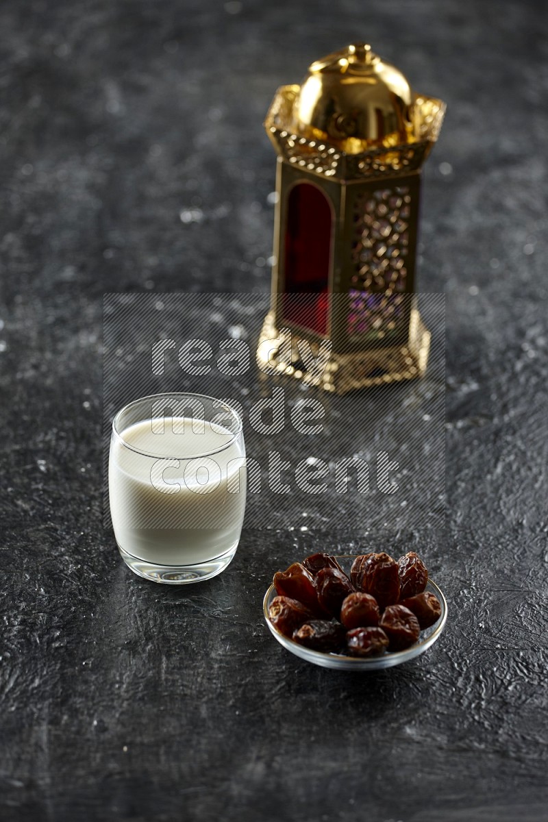 A golden lantern with different drinks, dates, nuts, prayer beads and quran on textured black background