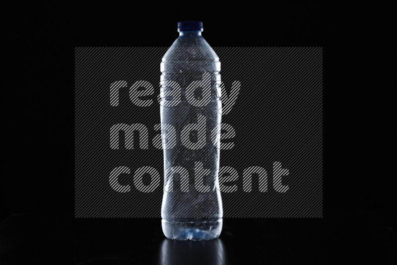 Water bottle with colored rim light against black background