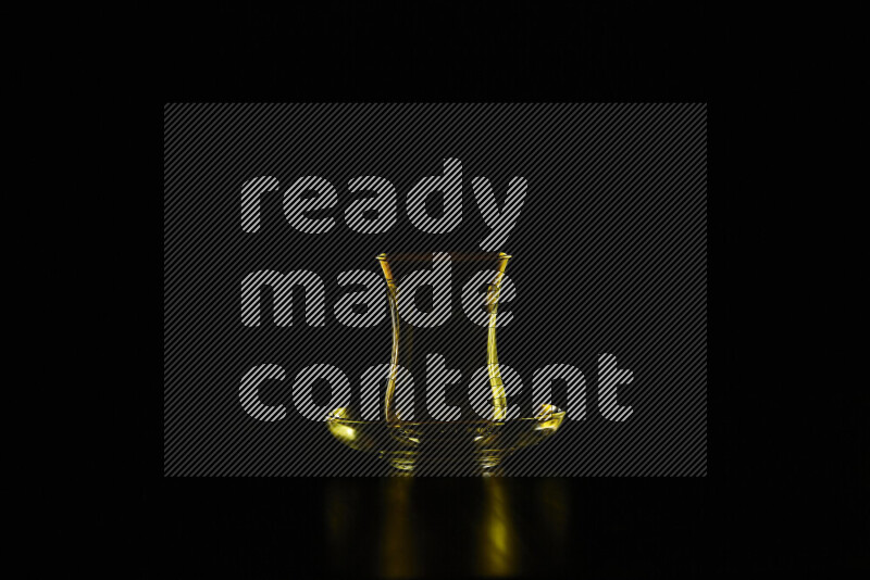 Glassware with rim light in yellow against black background