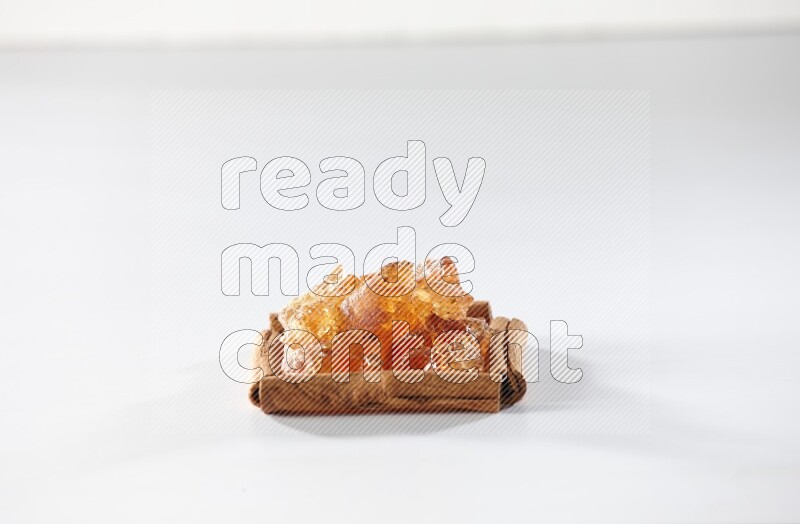 A single square of cinnamon sticks full of Arabic gum on white flooring
