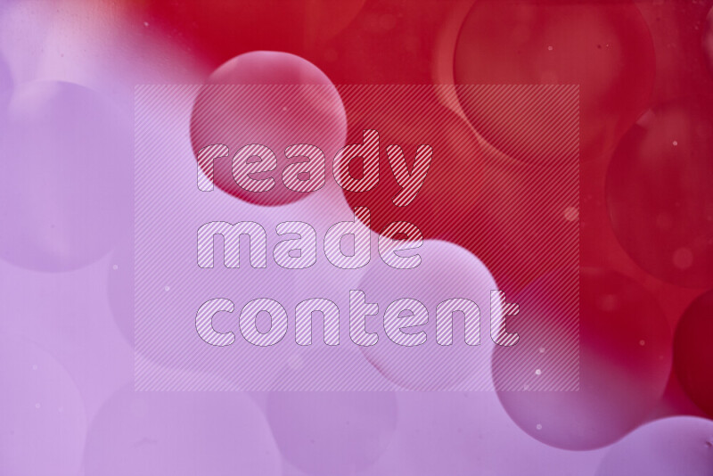 لقطات مقربة لفقاعات من الزيت على سطح الماء باللون الأحمر والوردي