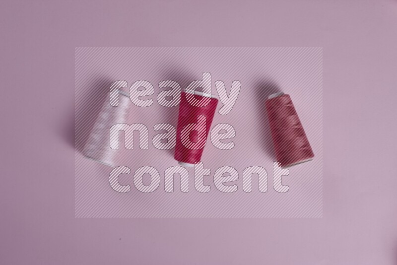 مجموعة من أدوات الخياطة والتفصيل زهرية اللون على خلفية زهرية