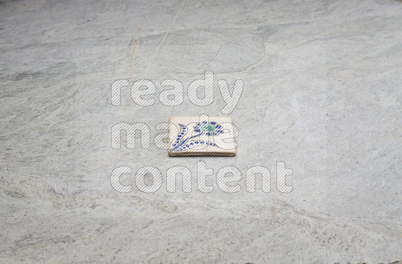 Top view shot of a pottery coaster\ tile on beige marble flooring