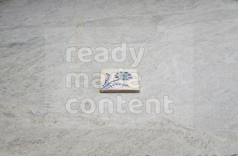 Top view shot of a pottery coaster\ tile on beige marble flooring