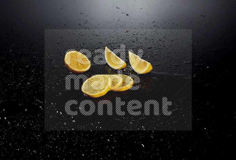 Lemon slices with water drops, and droplets on black background