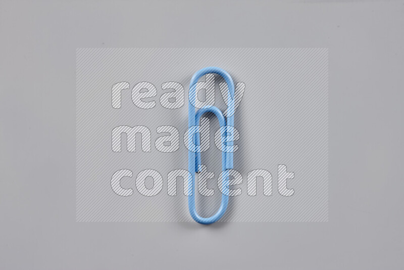 Blue paper clips isolated on a grey background