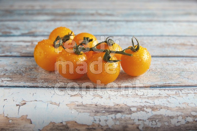 yellow cherry tomato vein on a textured blue wooden background 45 degree