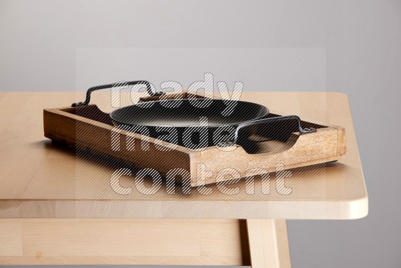 black plate on a light colored rectangular wooden tray with handles