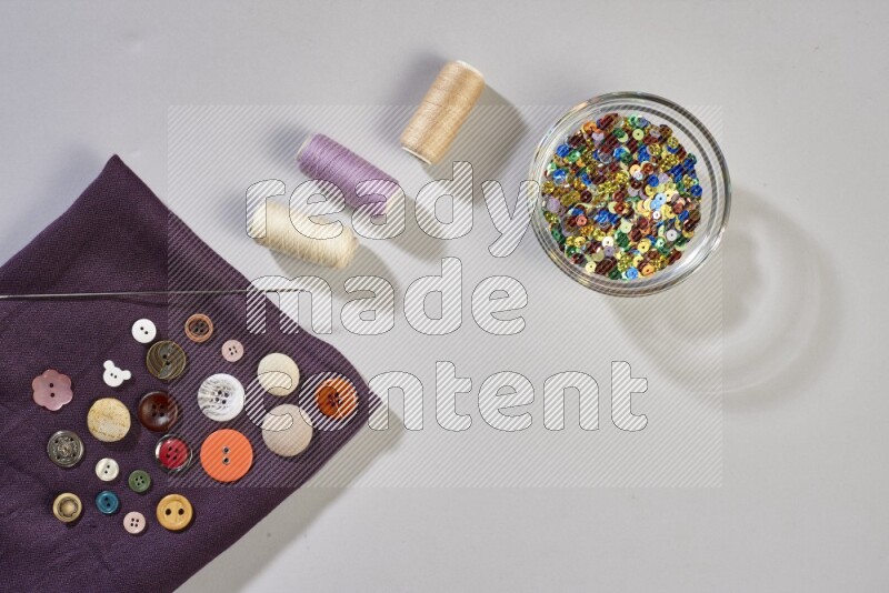 أقمشة متعددة الألوان مع لوازم الخياطة على خلفية رمادية