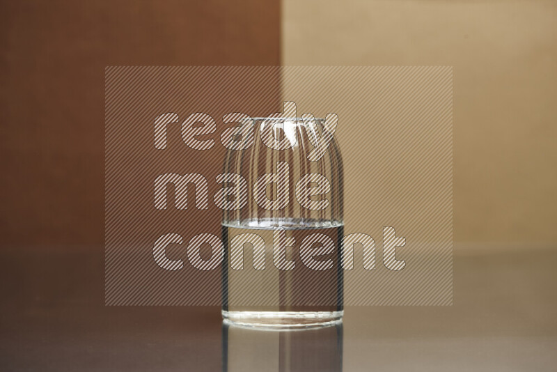 The image features a clear glassware filled with water, set against brown and beige background