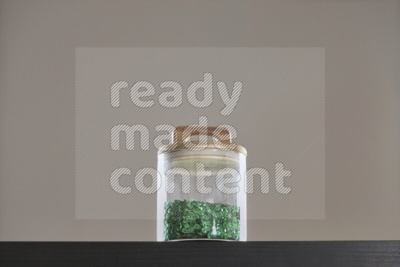 Sequins in a glass jar on black background