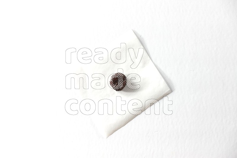 A dried plum on a piece of paper on a white background in different angles