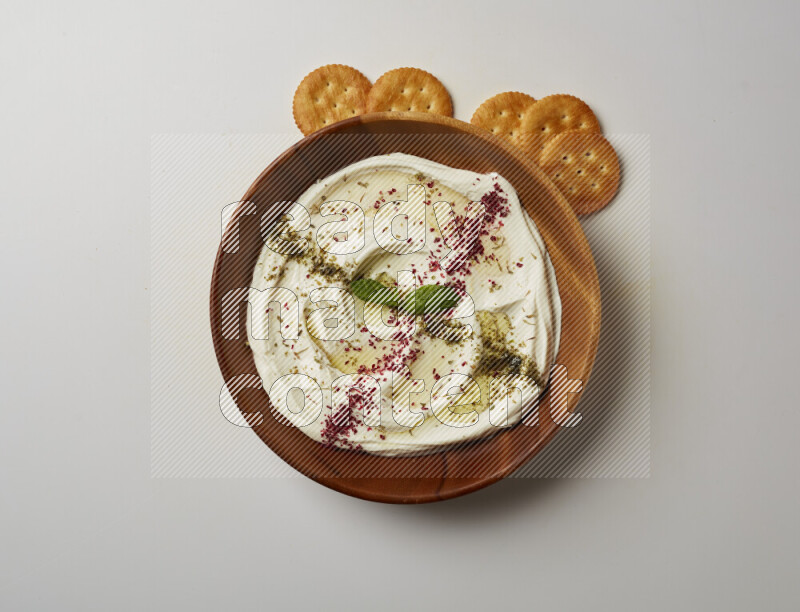 Lebnah garnished with  zattar , sumak & mint in a wooden plate on a white background