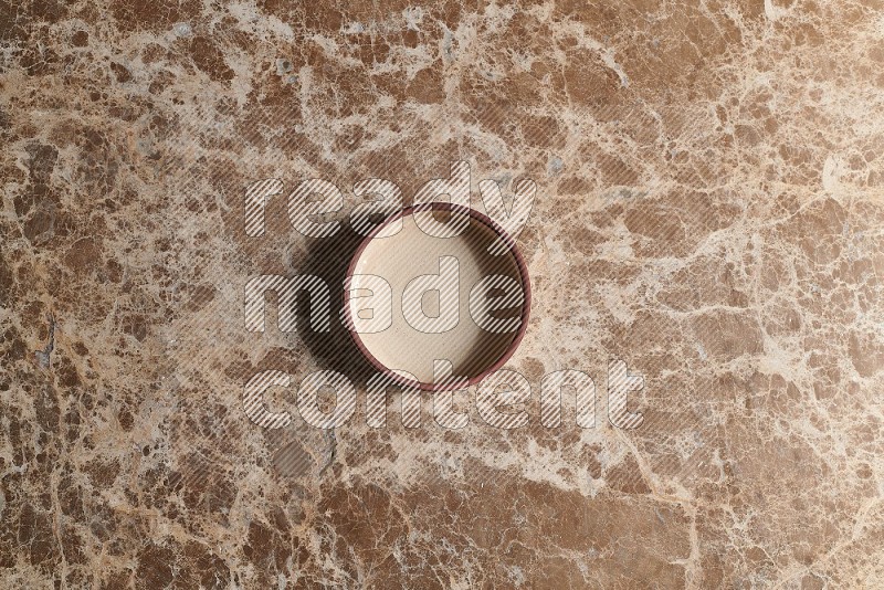 Top View Shot Of A Beige Pottery Oven Plate On beige Marble Flooring