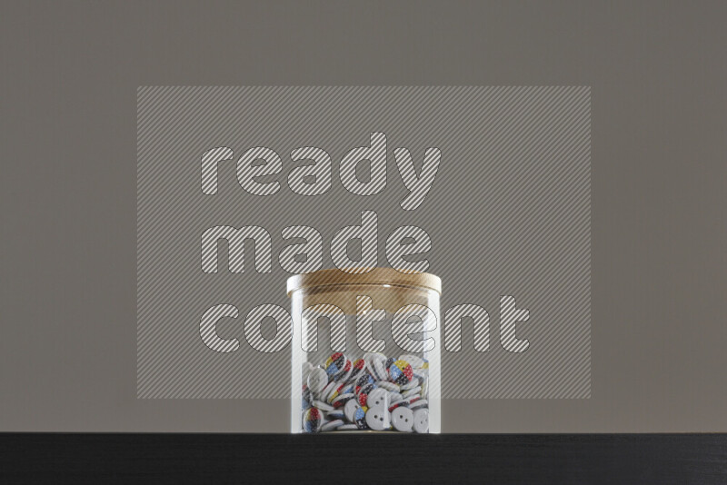 Buttons in a glass jar on black background