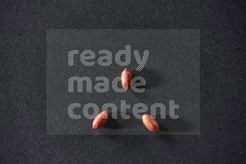 3 red skin peanuts on a black background in different angles