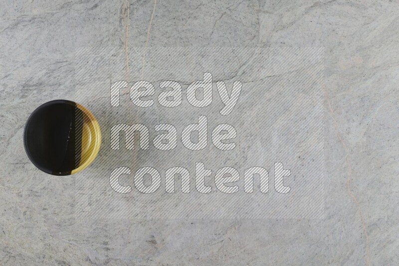 وعاء فخاري متعدد الألوان على خلفية من الرخام الرمادي