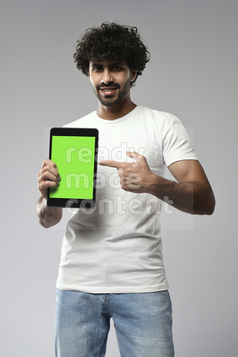 A man wearing casual standing and showing a tablet screen on white background