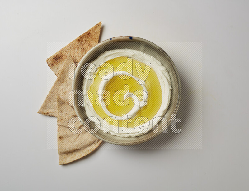 Lebnah garnished with olive oil in a grey pottery plate on a white background