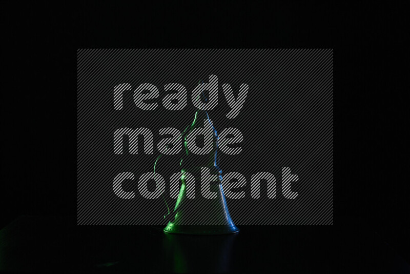 A turkish coffee pot with colored rim light against black background