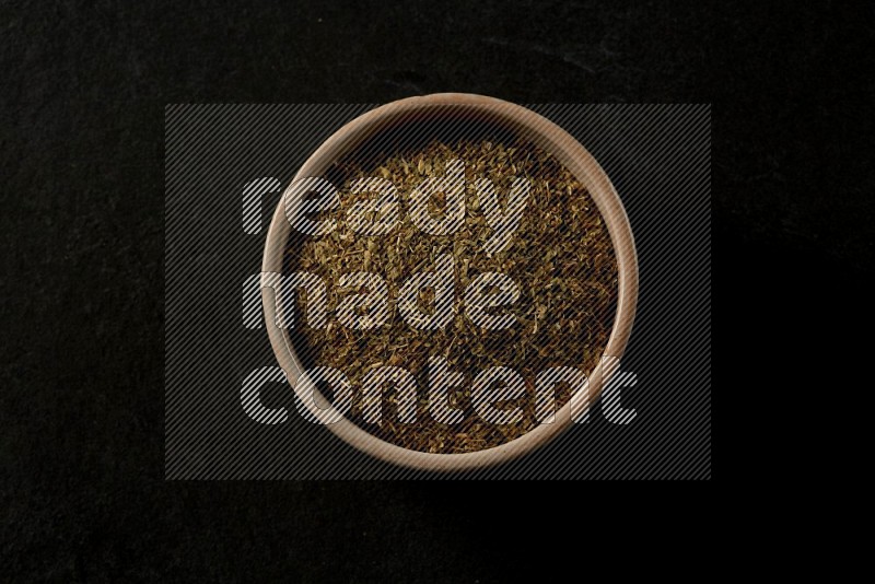 multi color round sauce bowl filled with herbs on grey textured countertop