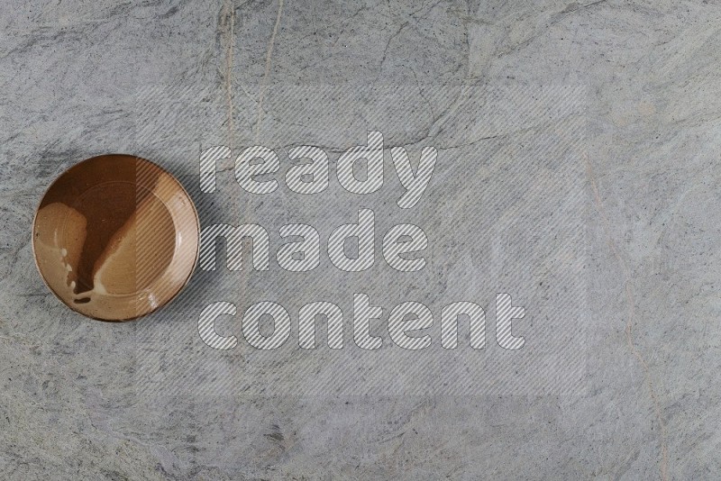 Top View Shot Of A Multicolored Pottery Plate On Grey Marble Flooring