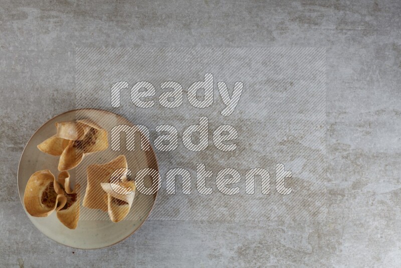 wonton cups with soy sauce ramkin on multi colored pottery on grey textured counter top