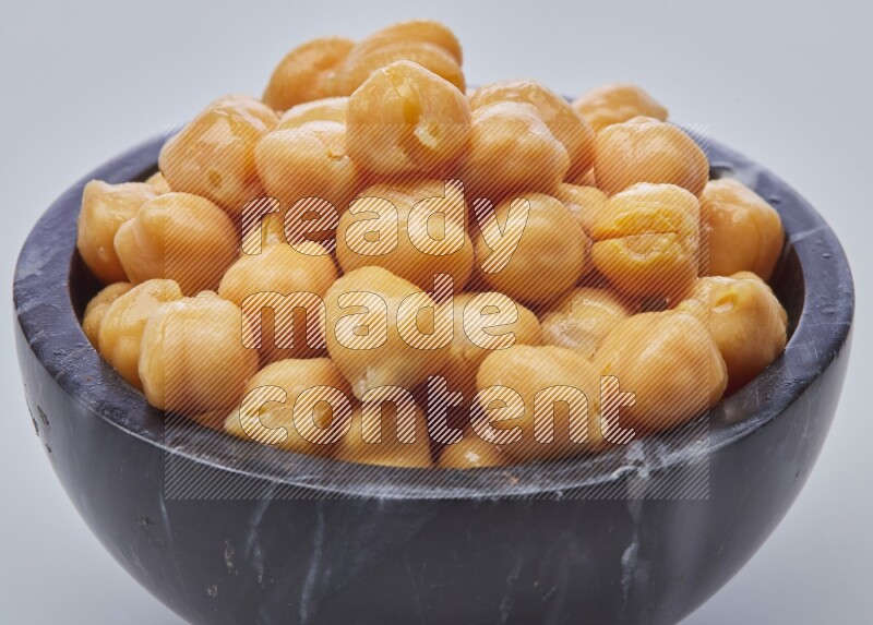 Close up of a boiled chickpeas in a container on white background
