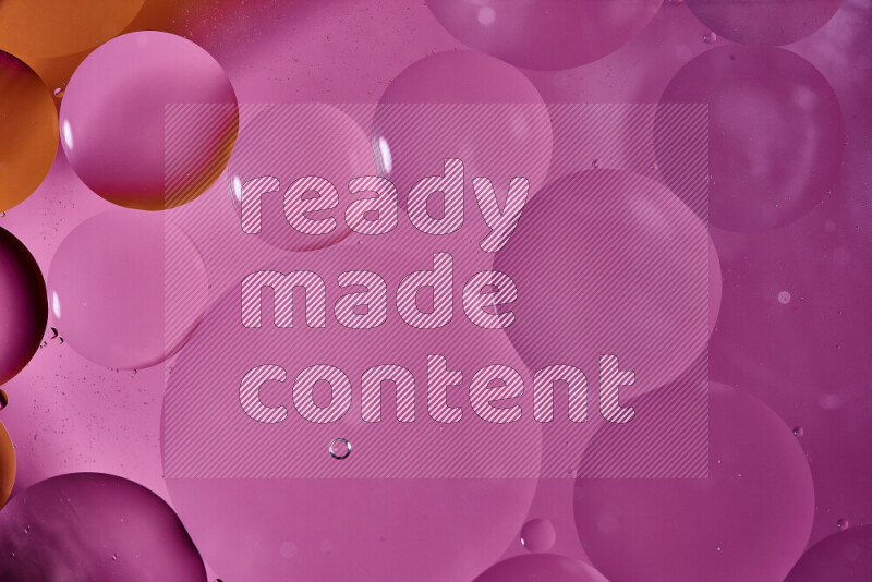 لقطات مقربة لفقاعات من الزيت على سطح الماء باللون البرتقالي والوردي