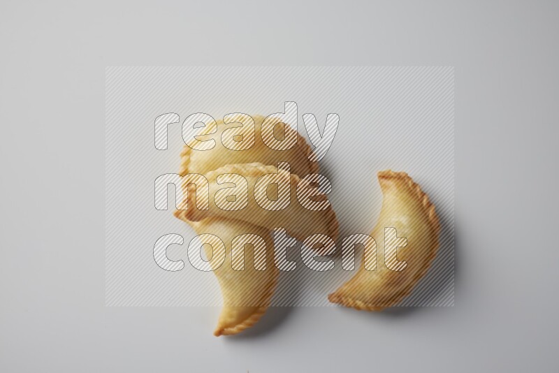 Four fried sambosa from a top angle on a white background