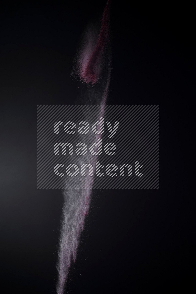 A side view of red powder explosion on black background