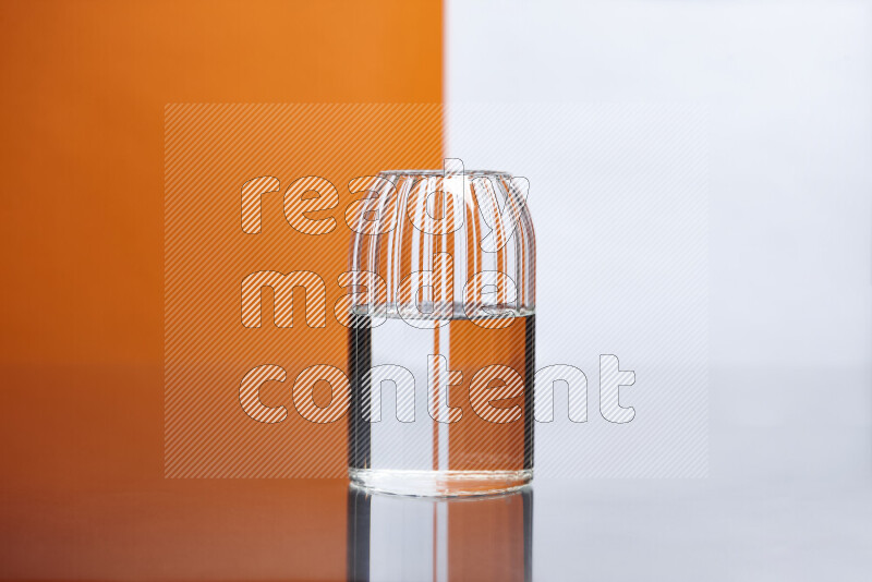 The image features a clear glassware filled with water, set against white and orange background