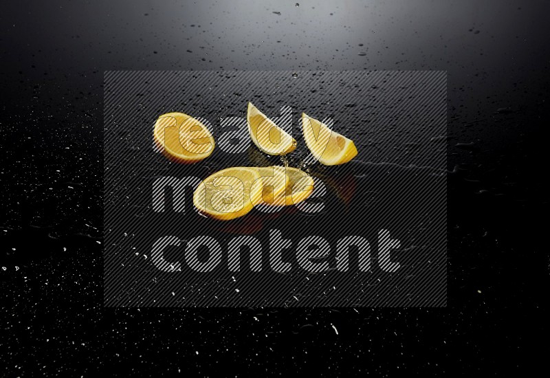 Lemon slices with water drops, and droplets on black background