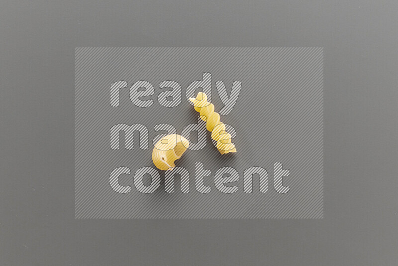 Pipe pasta with other types of pasta on grey background