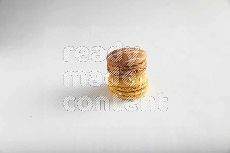 45º Shot of of two assorted Brown Irish Cream, and Yellow Piña Colada macarons on white background