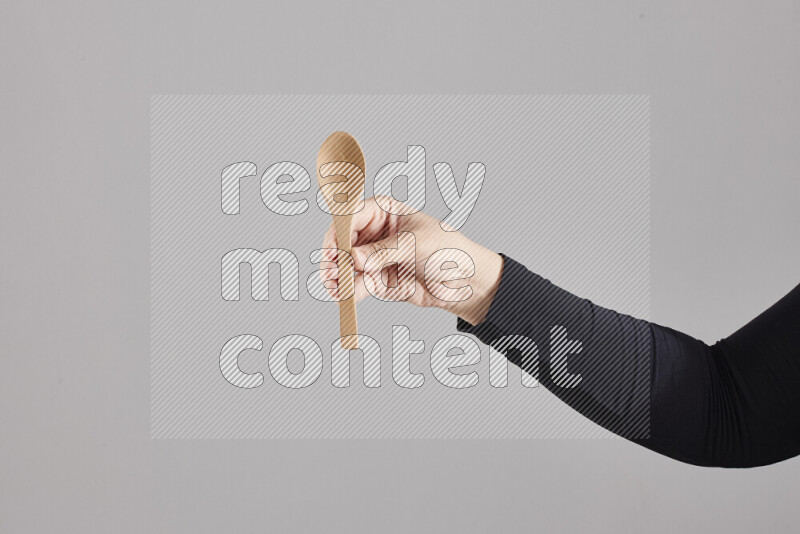 A woman in black abaya holding different wooden essentials in different positions
