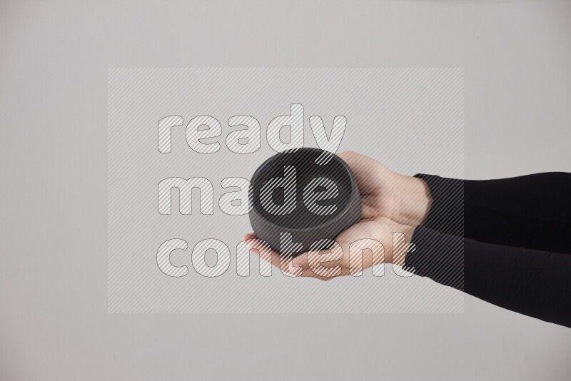 امرأة ترتدي عباءة سوداء تحمل أدوات فخارية مختلفة في أوضاع متعددة