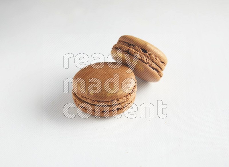 45º Shot of two Brown Coffee macarons on white background